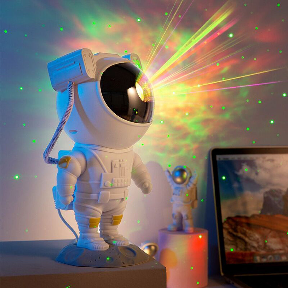 Astronaut galaxy projector lamp casting colorful starry sky lights in a room with a laptop nearby