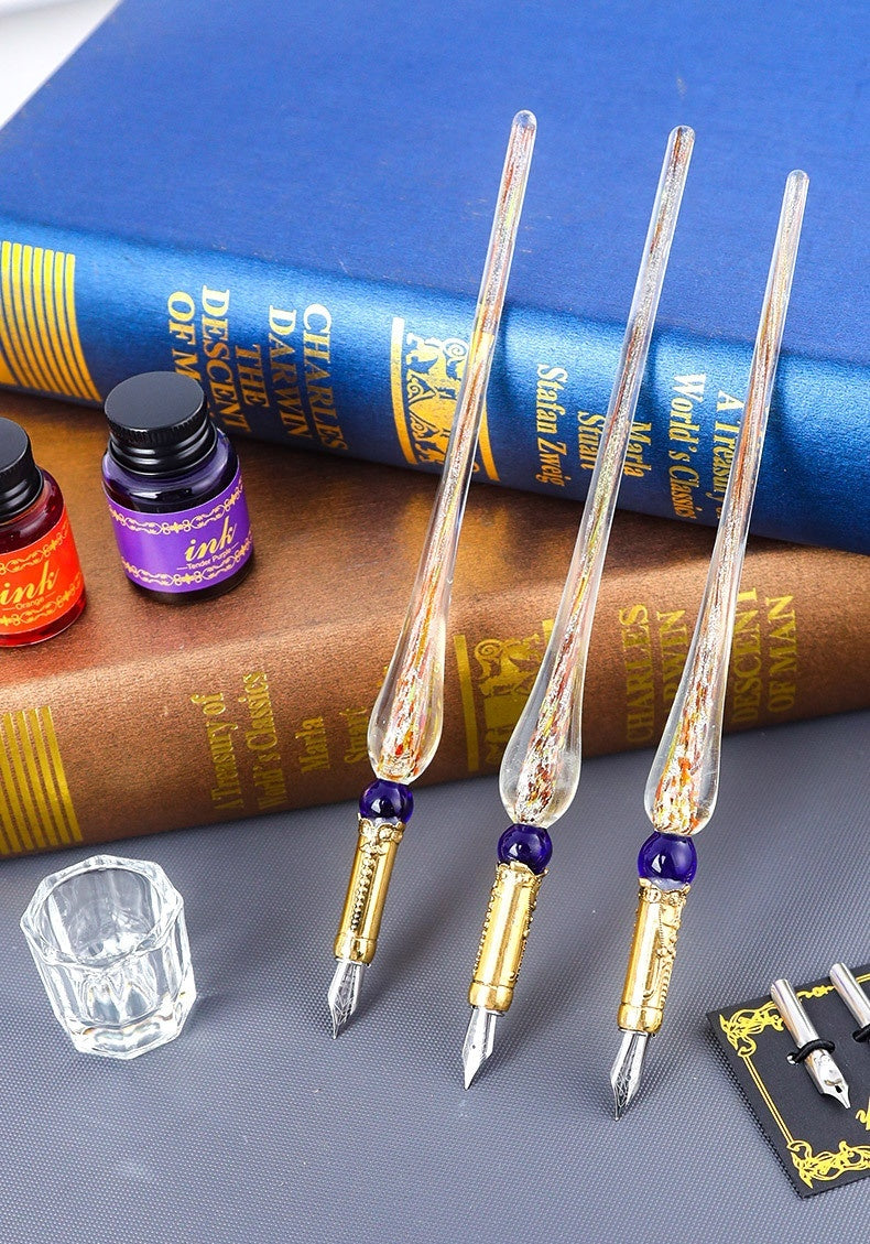 Classical Feather Pen Set with three intricate glass pens gold accents ink bottles and vintage books