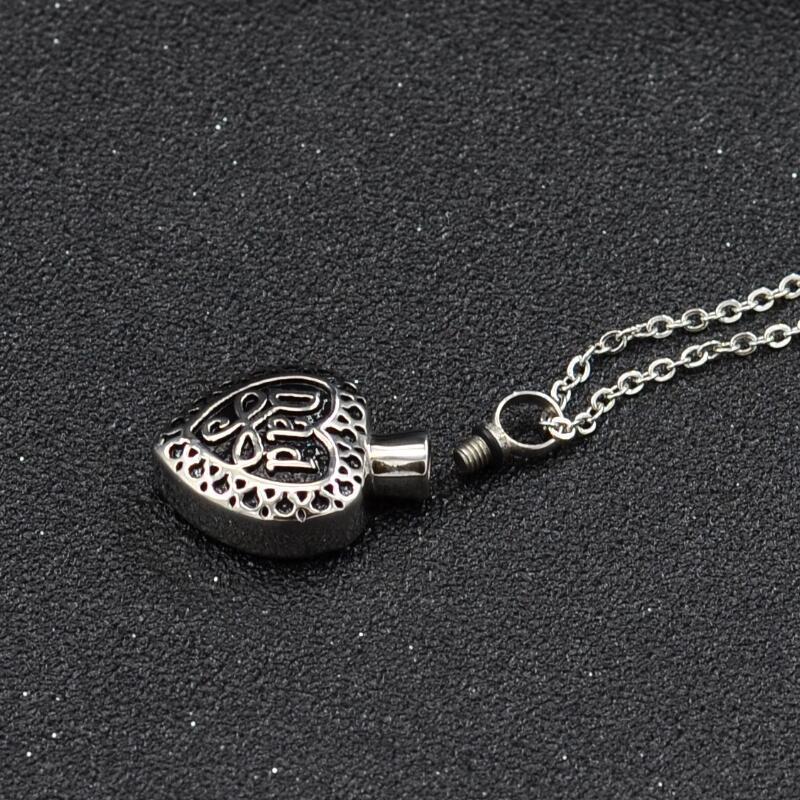 Silver heart urn pendant for ashes with intricate design and screw top on a chain necklace