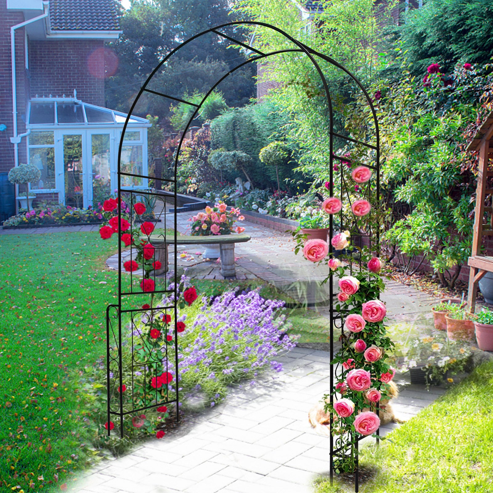 Black decorative garden arch for climbing plants adorned with vibrant roses in a lush garden setting