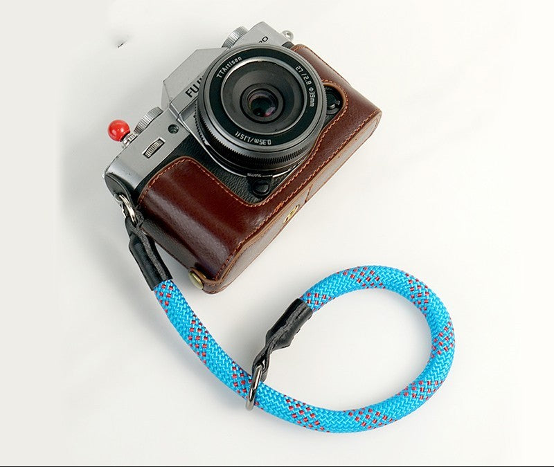 Durable camera wrist strap attached to a silver and brown vintage camera for secure handling