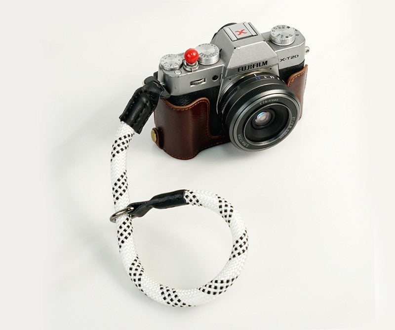 Durable camera wrist strap in white with black accents attached to a Fujifilm camera
