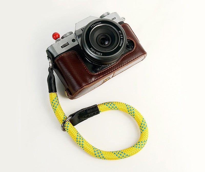 Durable camera wrist strap in yellow and blue attached to silver and brown vintage camera
