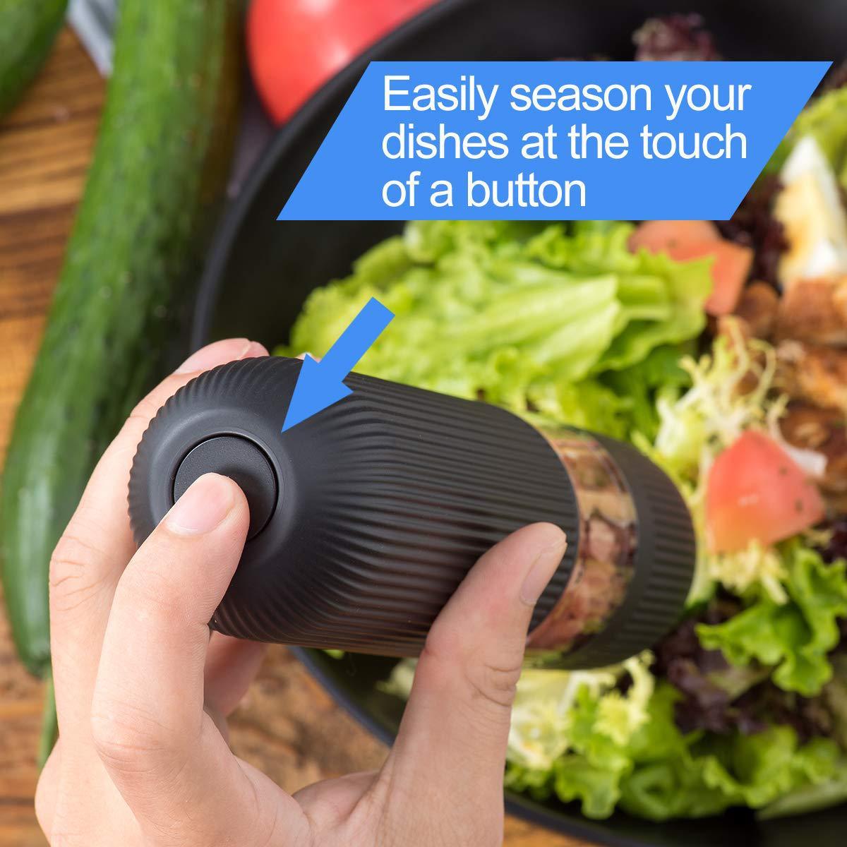 Hand holding electric pepper grinder with push button for easy seasoning over salad