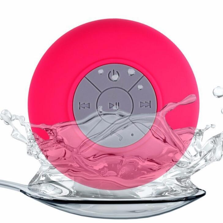 Sheila Merchandise mini waterproof Bluetooth speaker in pink with control buttons splashing in water