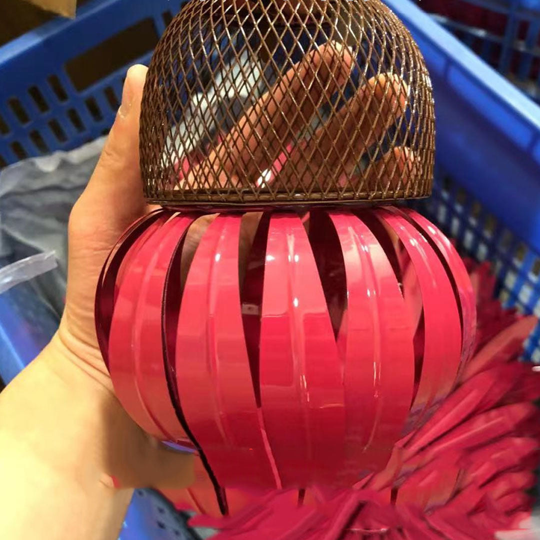 Sheila Merchandise petal shaped bird feeder in pink with metal mesh cover held in hand