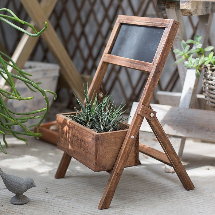 Rustic wooden garden decoration planter with built-in chalkboard displaying succulent plants