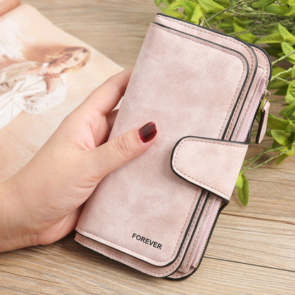 Matte PU leather multi function wallet for women in light pink color held in hand with snap closure