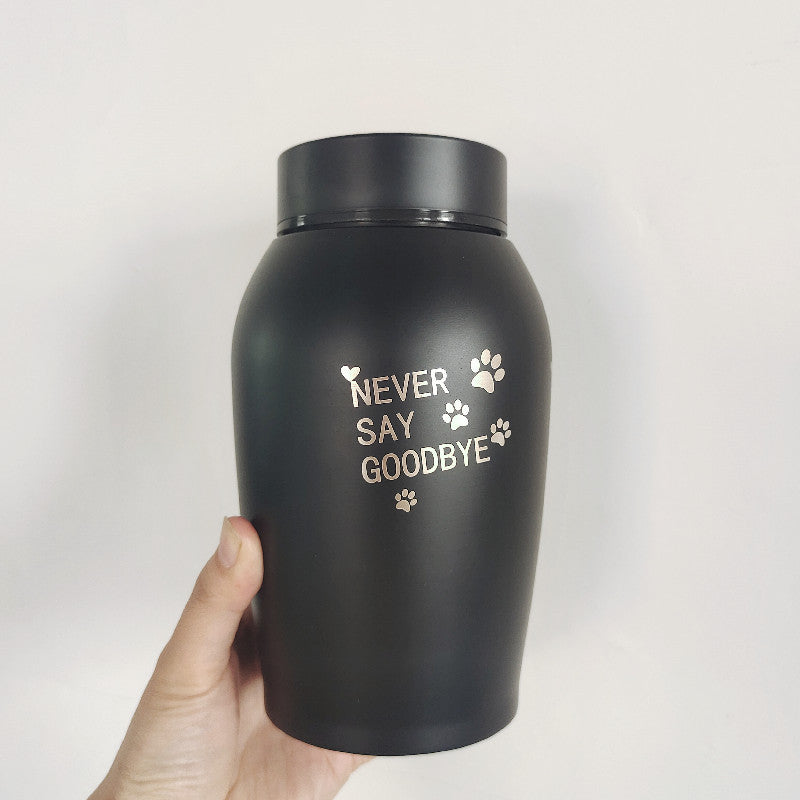 Black stainless steel pet urn with never say goodbye text and paw prints held in hand