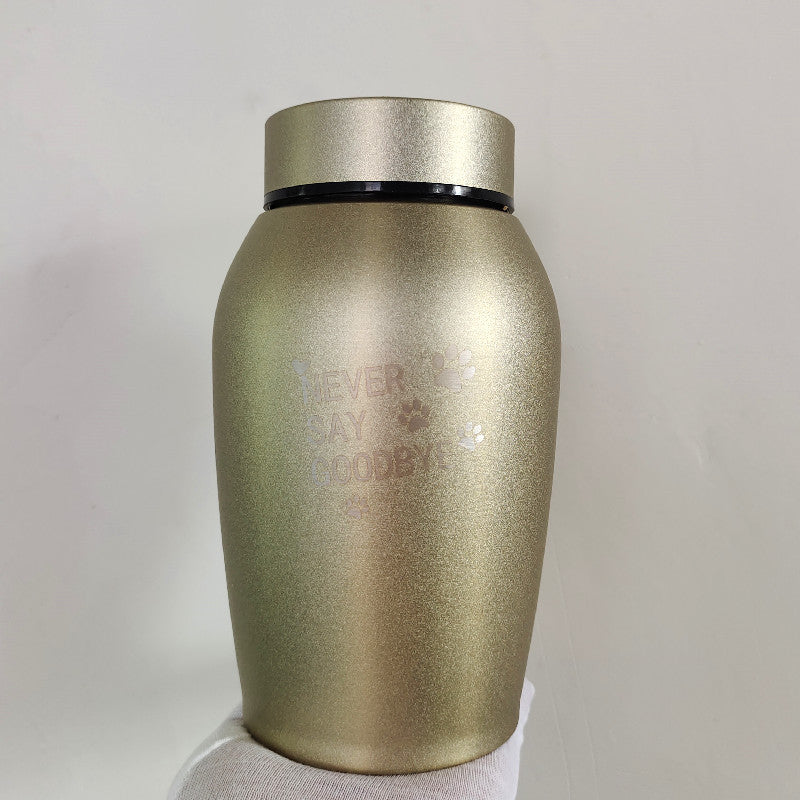 Gold metal seal stainless steel pet urn with Never Say Goodbye inscription held in hand
