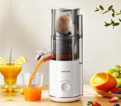 Sheila Merchandise home juicing machine pouring fresh orange juice into a glass on wooden table