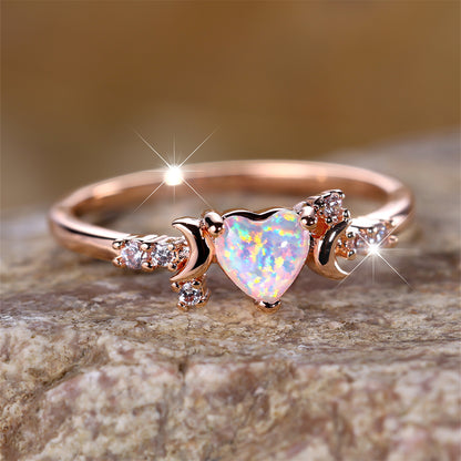 Rose gold moonstone love ring with heart-shaped center stone and three claw design on both sides