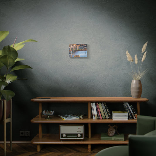 Newport Oregon bridge canvas art displayed on a wooden shelf with plants and decor