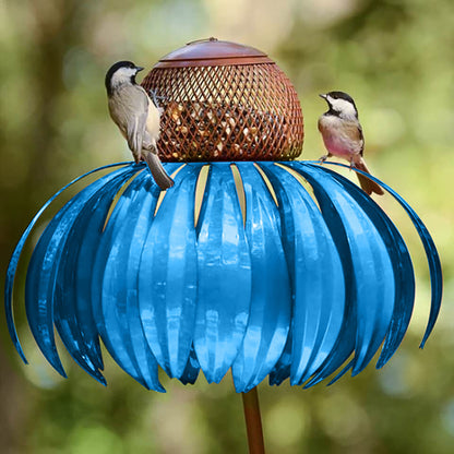 Blue petal shaped bird feeder with two small birds perched on it in a garden setting