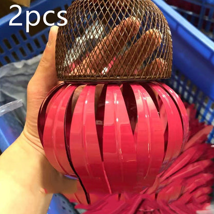 Hand holding a pink petal shaped bird feeder with a brown mesh top from Sheila Merchandise