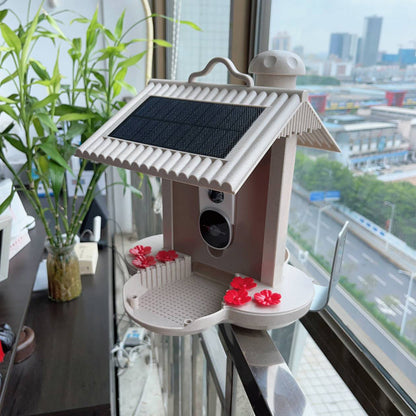 Smart hummingbird feeder with solar panel and flower-shaped feeding stations placed on a window sill
