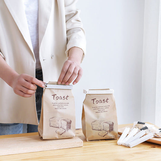 Reusable food sealing clips from Sheila Merchandise sealing toast bags on wooden table