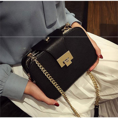 Black Sheila Merchandise versatile fashion handbags with gold chain strap held by person in blue blouse and white skirt