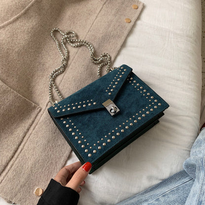 Women's red leather purse with chain featuring studded design and silver clasp