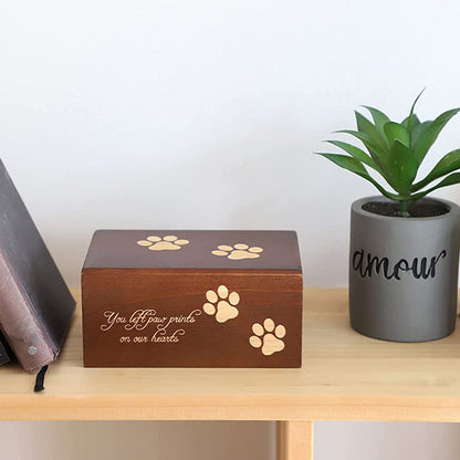 Wooden pet urn for ashes with paw print design and sentimental inscription on a wooden shelf